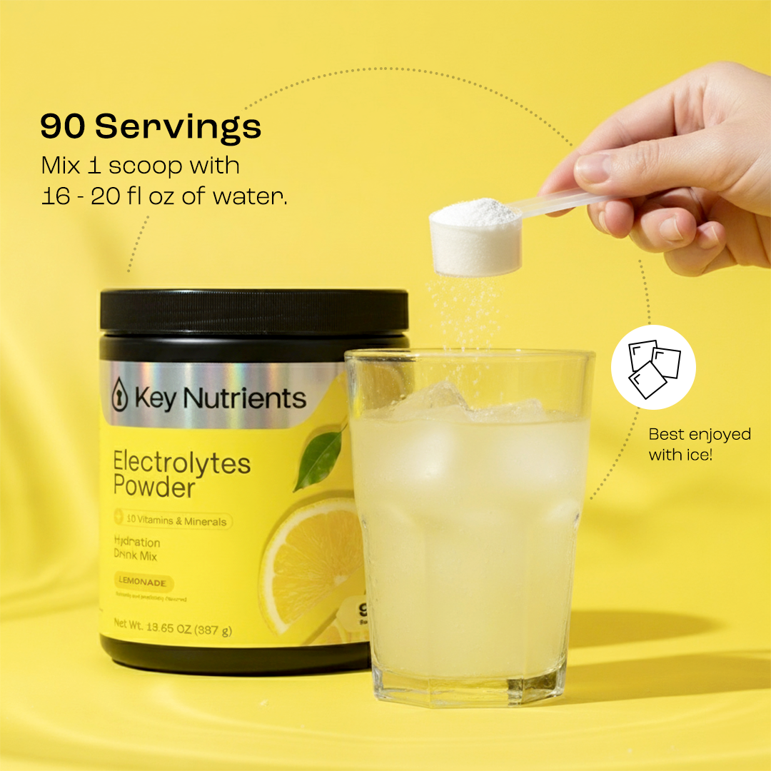 Electrolytes Powder tub with scoop over a glass of lemonade drink