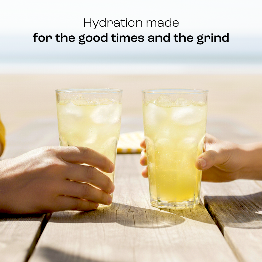 Two glasses of lemonade electrolyte drink with ice, held by hands