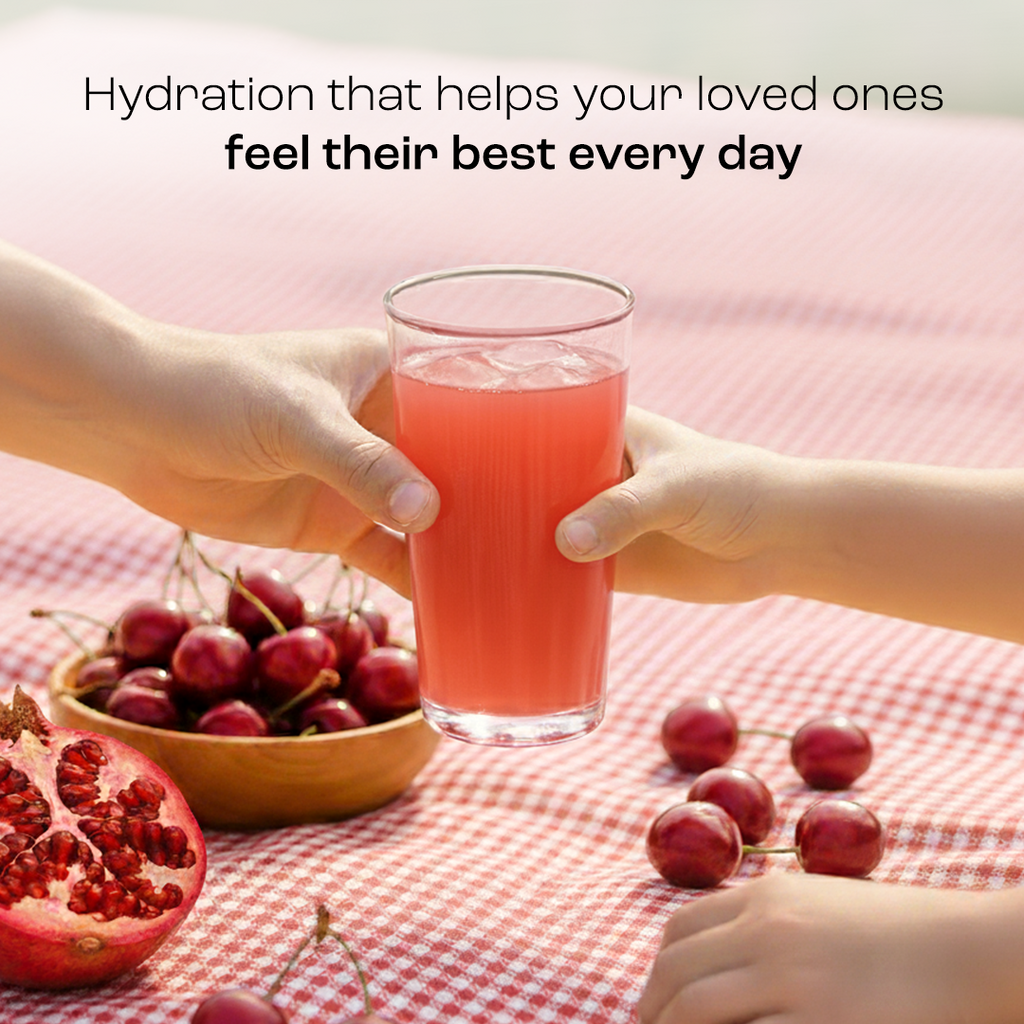Red electrolyte drink in a glass held by hands with cherries and pomegranate