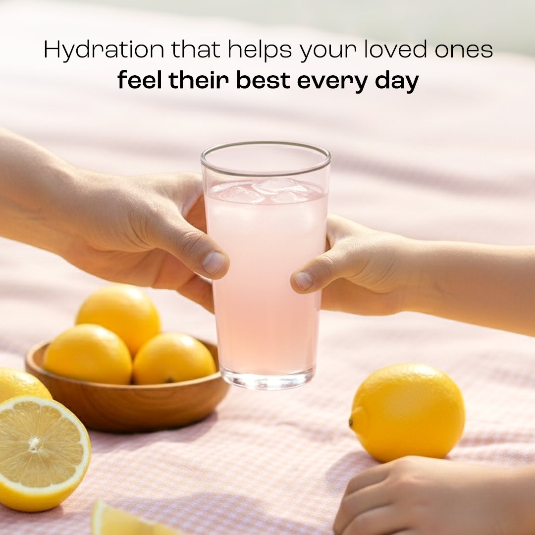 Electrolyte drink in a tall glass held by hands, with lemon slices
