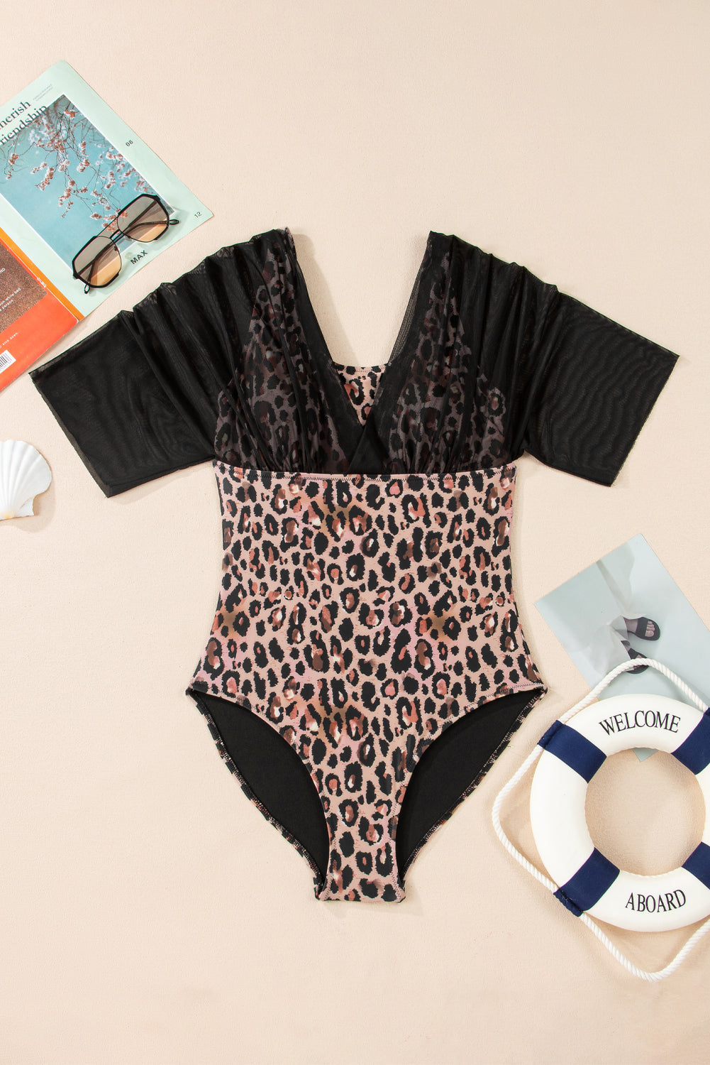 Flat lay: leopard-print one-piece swimsuit with black mesh half-sleeves and V-neck