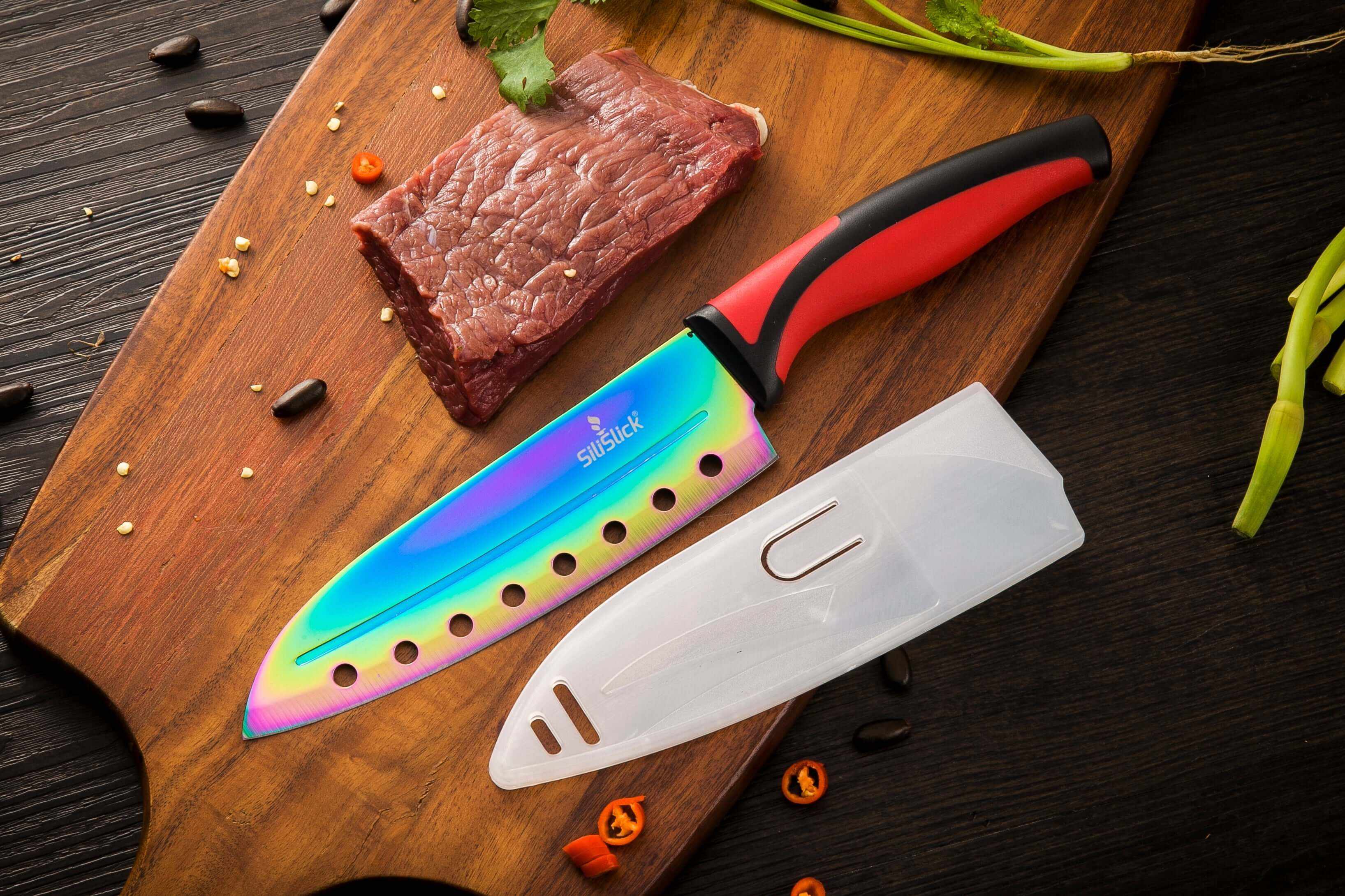 Chef-style knife with red handle and rainbow blade, plus clear sheath