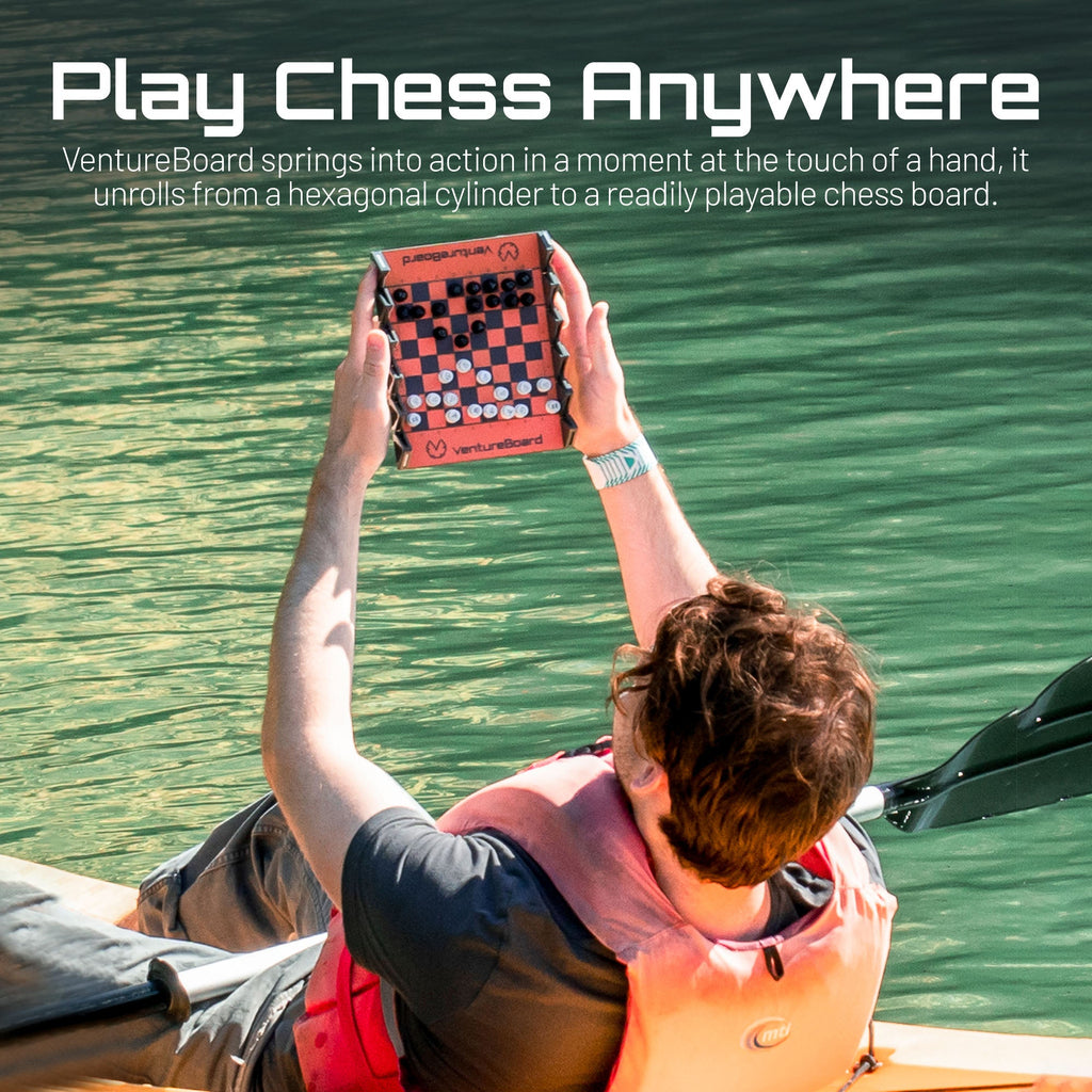 Mini échecs Noir tenu en main, échiquier en cours de déploiement