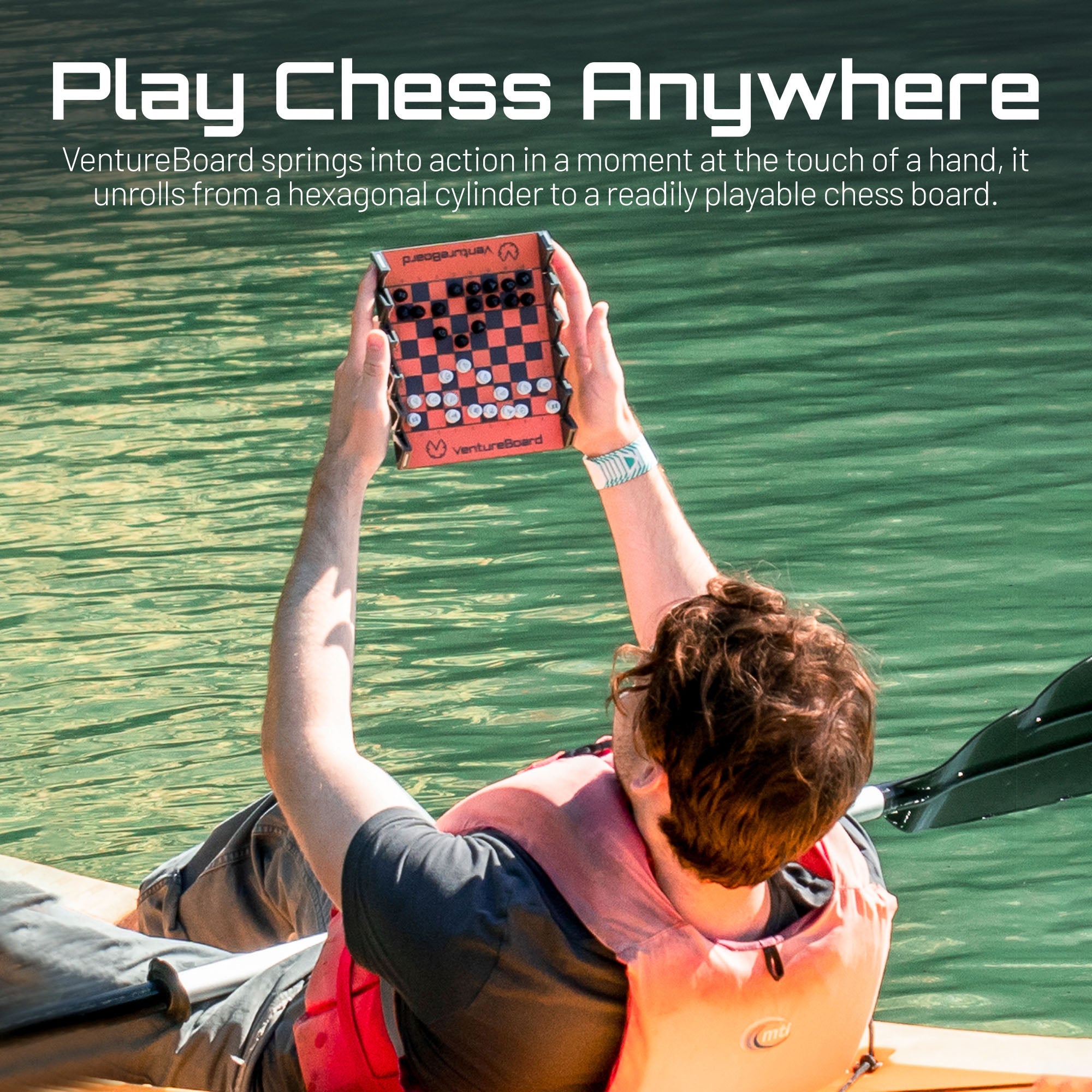 Mini échecs Noir tenu en main, échiquier en cours de déploiement