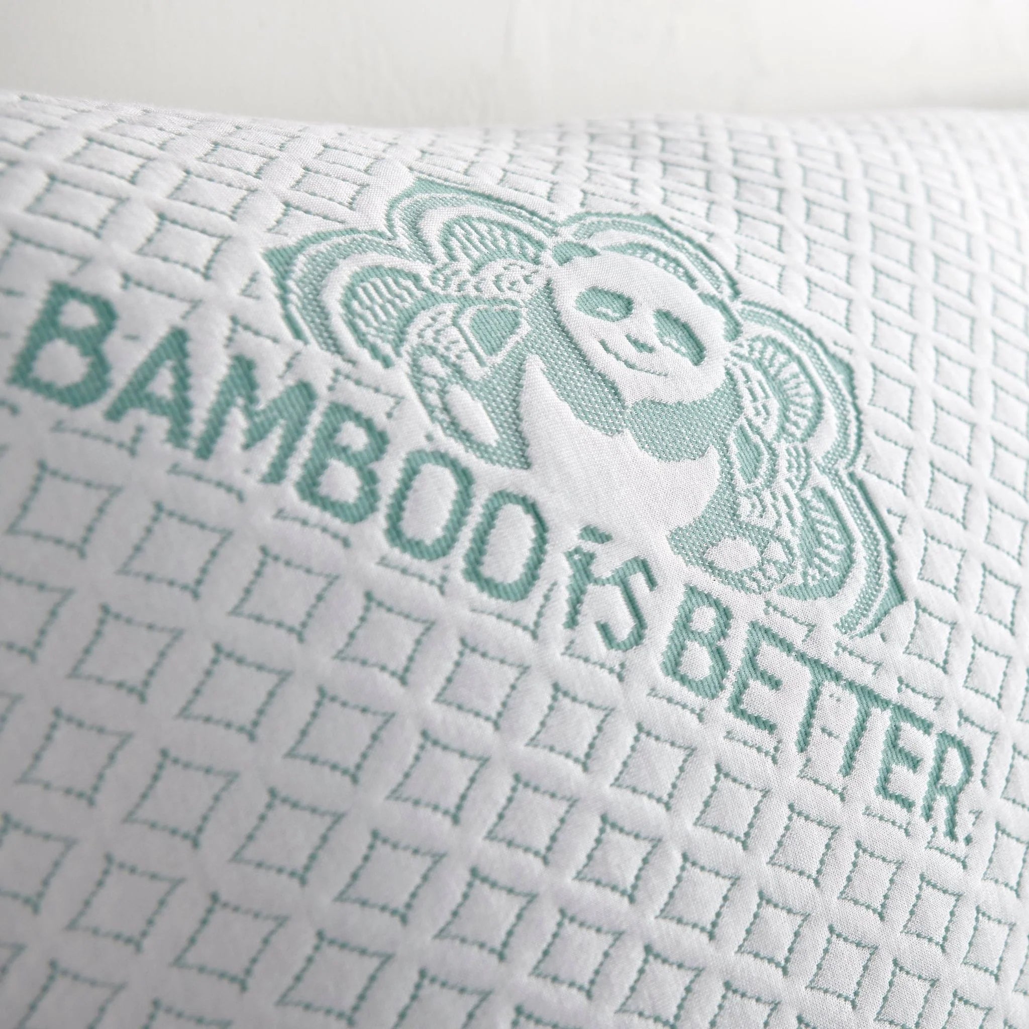 Bamboo cooling pillow close-up: white fabric with mint grid weave and bear graphic