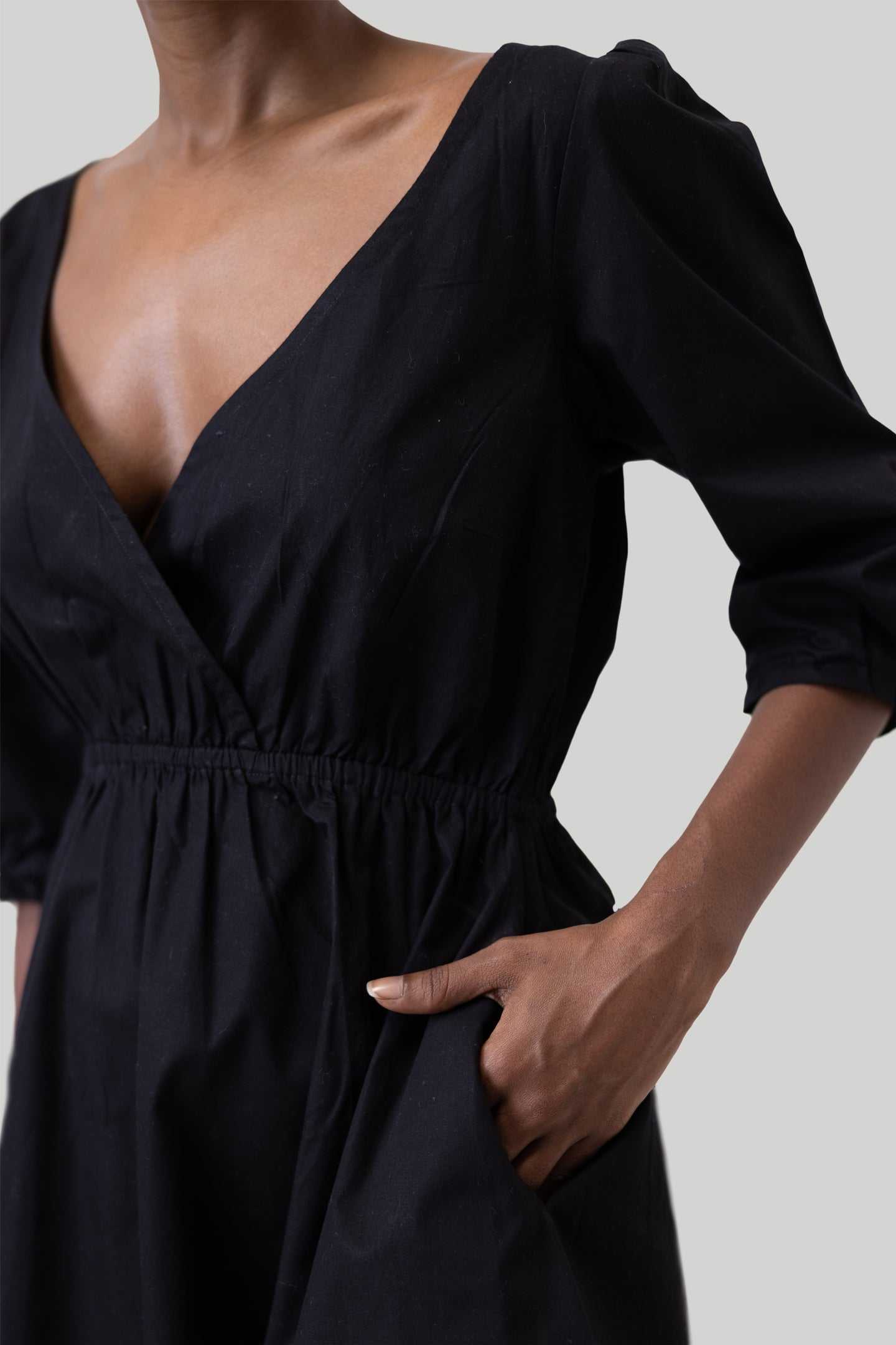 Black gathered-waist short dress, deep V neckline, puffed elbow-length sleeves