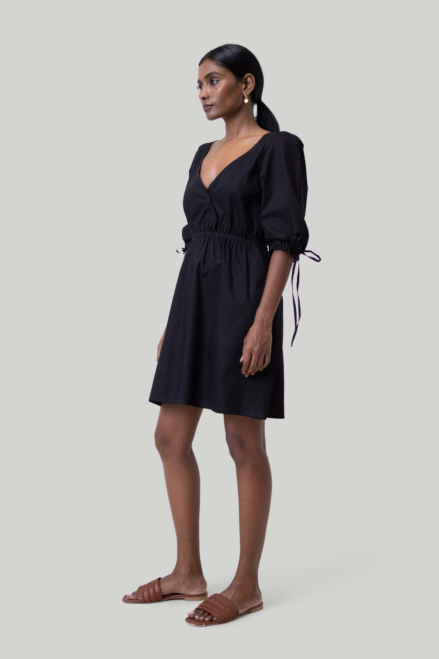 Black short dress side view, gathered waist and bow-tied elbow sleeves