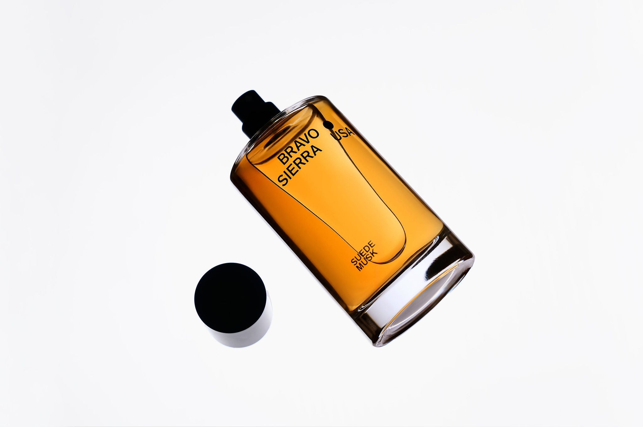 Body Fragrance Suede Musk: ovale Flasche, schwarz-amber mit Aufdruck
