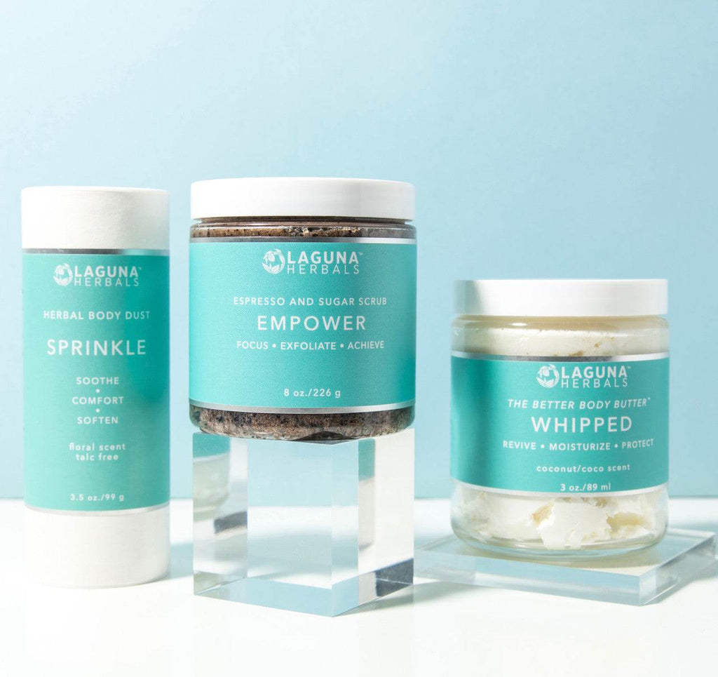 Coffee Scrub-Glas mit dunklem Peeling, umgeben von weiteren Pflegeprodukten