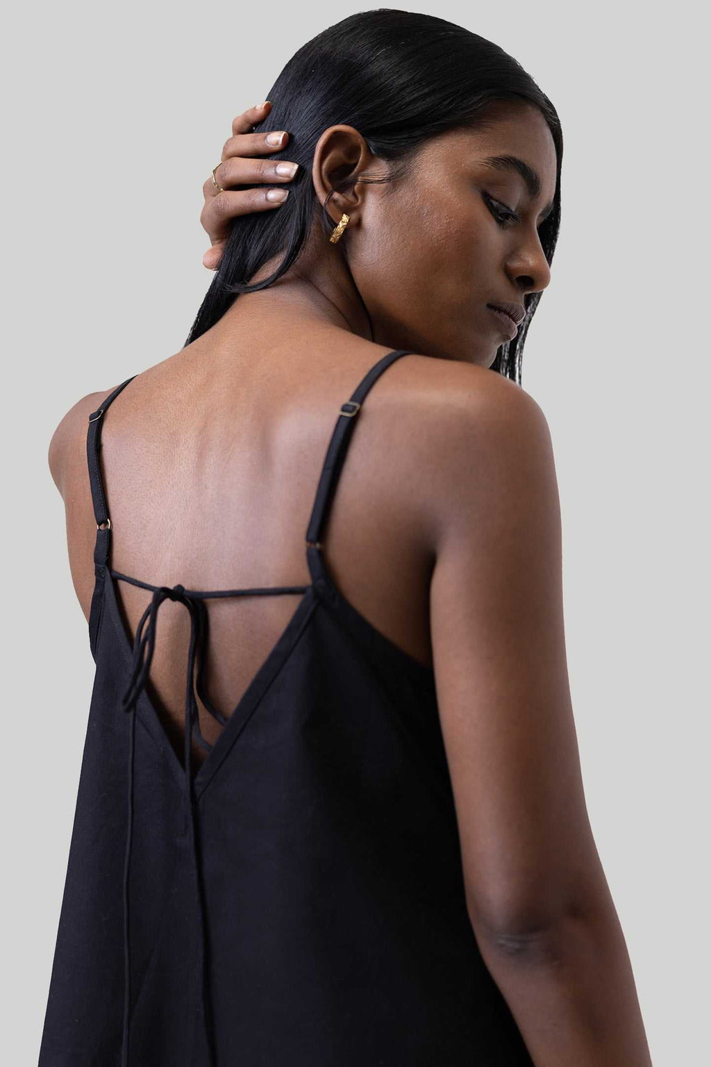 Black tent dress close-up: crisscross open back with thin straps