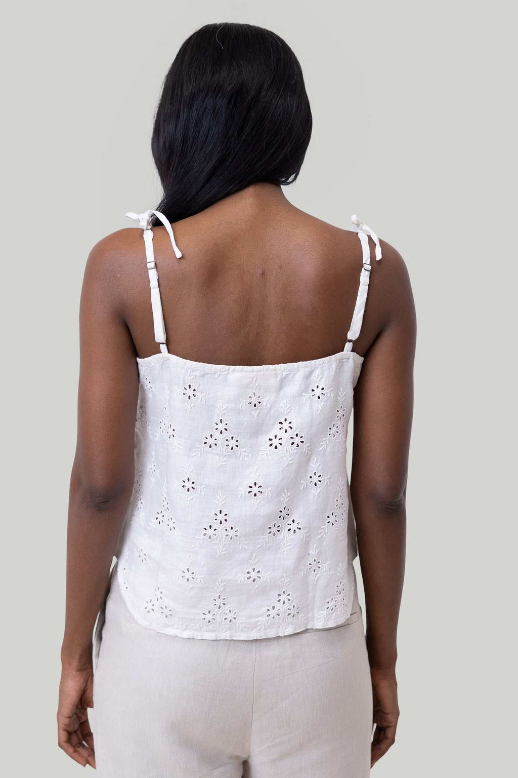 Back view of white tie-up camisole with thin straps and eyelet embroidery