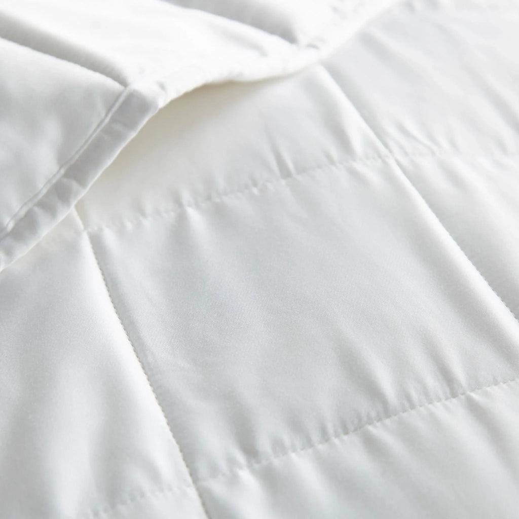 Close-up of white comforter fabric with stitched seam lines