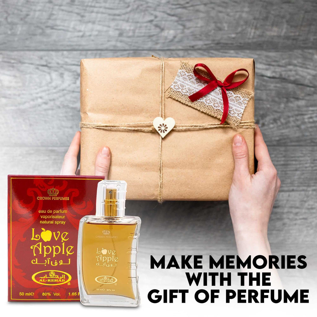 Hands holding gift-wrapped box with small “Love Apple” perfume bottle