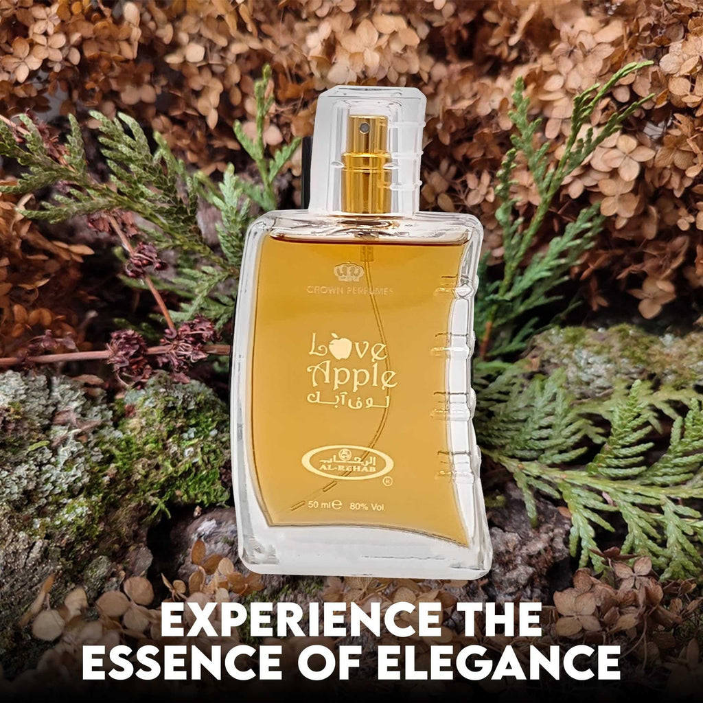 Square clear perfume bottle with gold “Love Apple” label in outdoor-like setting