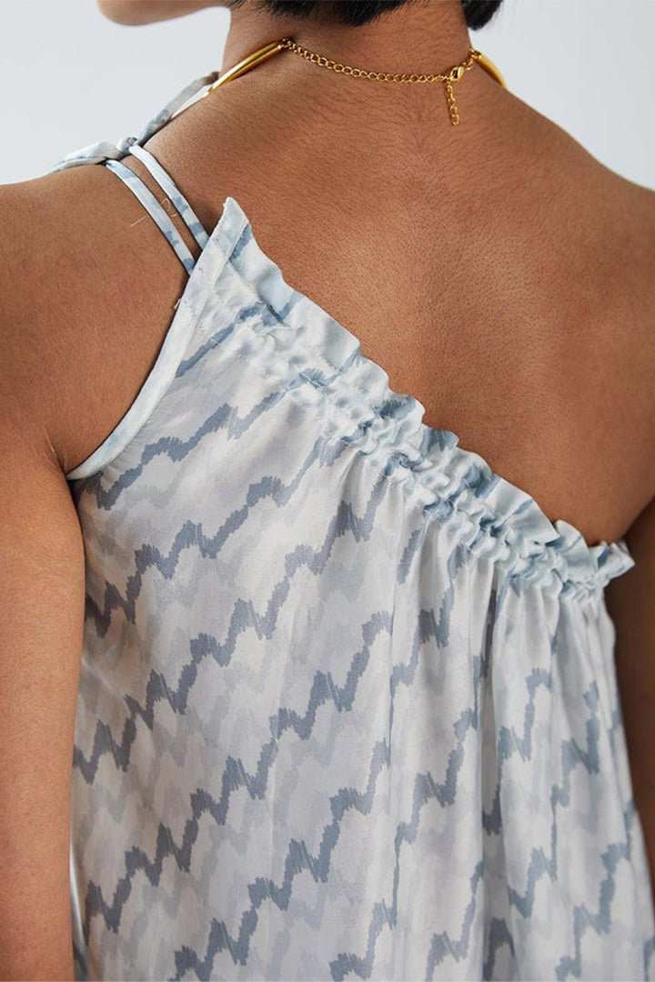 Moonlight Dress close-up: draped one-shoulder gathers with light blue zigzag print