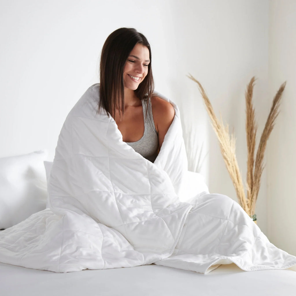 White comforter being tucked around sleeper, quilted baffle stitching