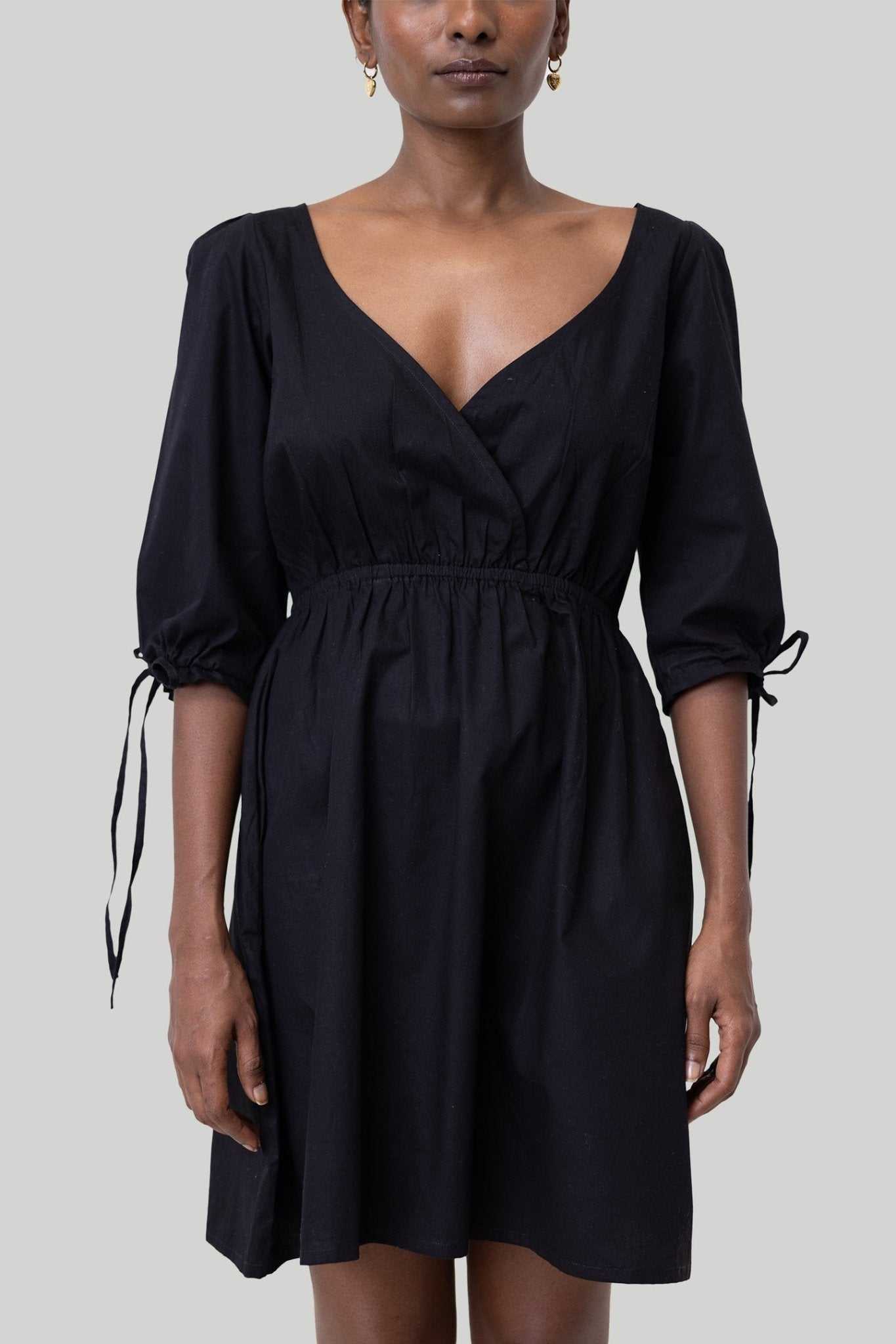 Black short dress with three-quarter puff sleeves, V-neck, and tied sleeve cuffs