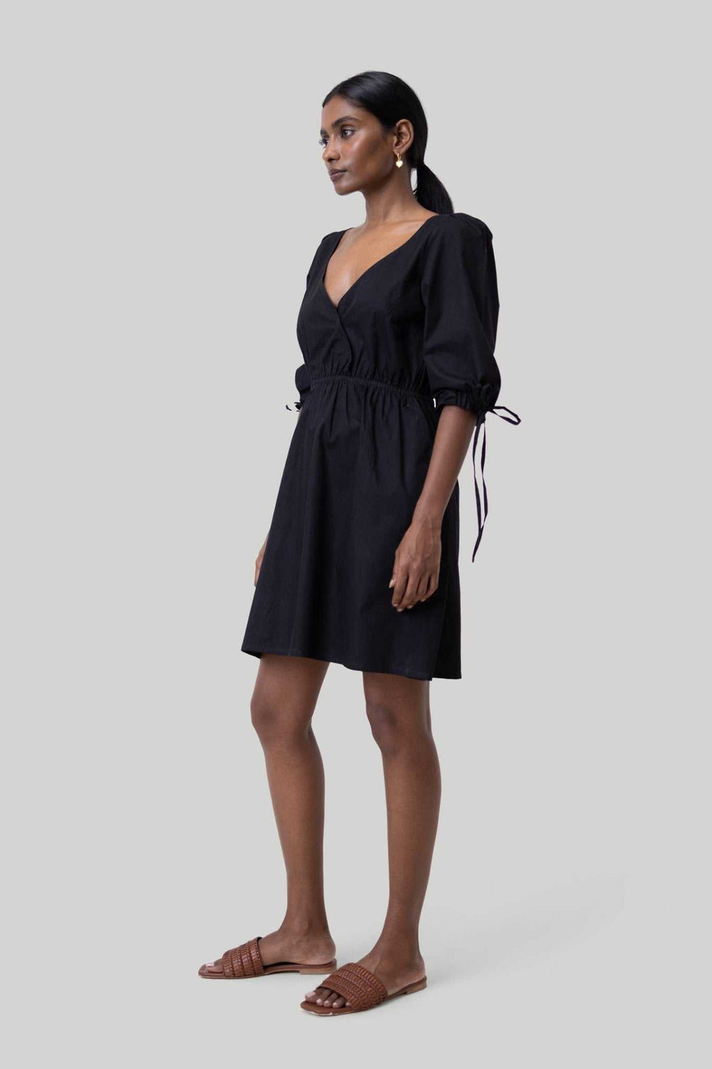 Black short dress with elbow-length puff sleeves and adjustable tie waist