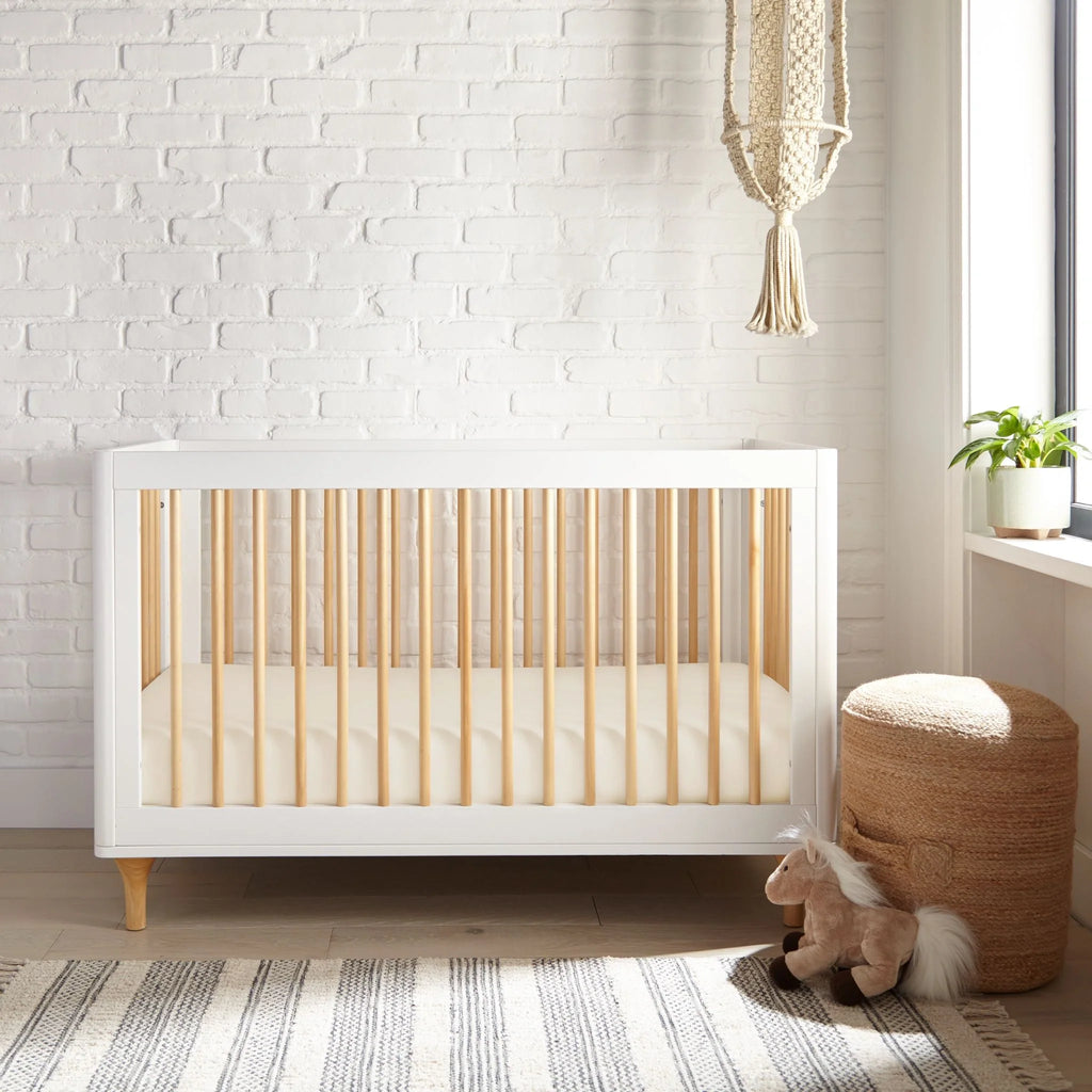 White crib fitted sheet, neatly tucked for a secure snug fit
