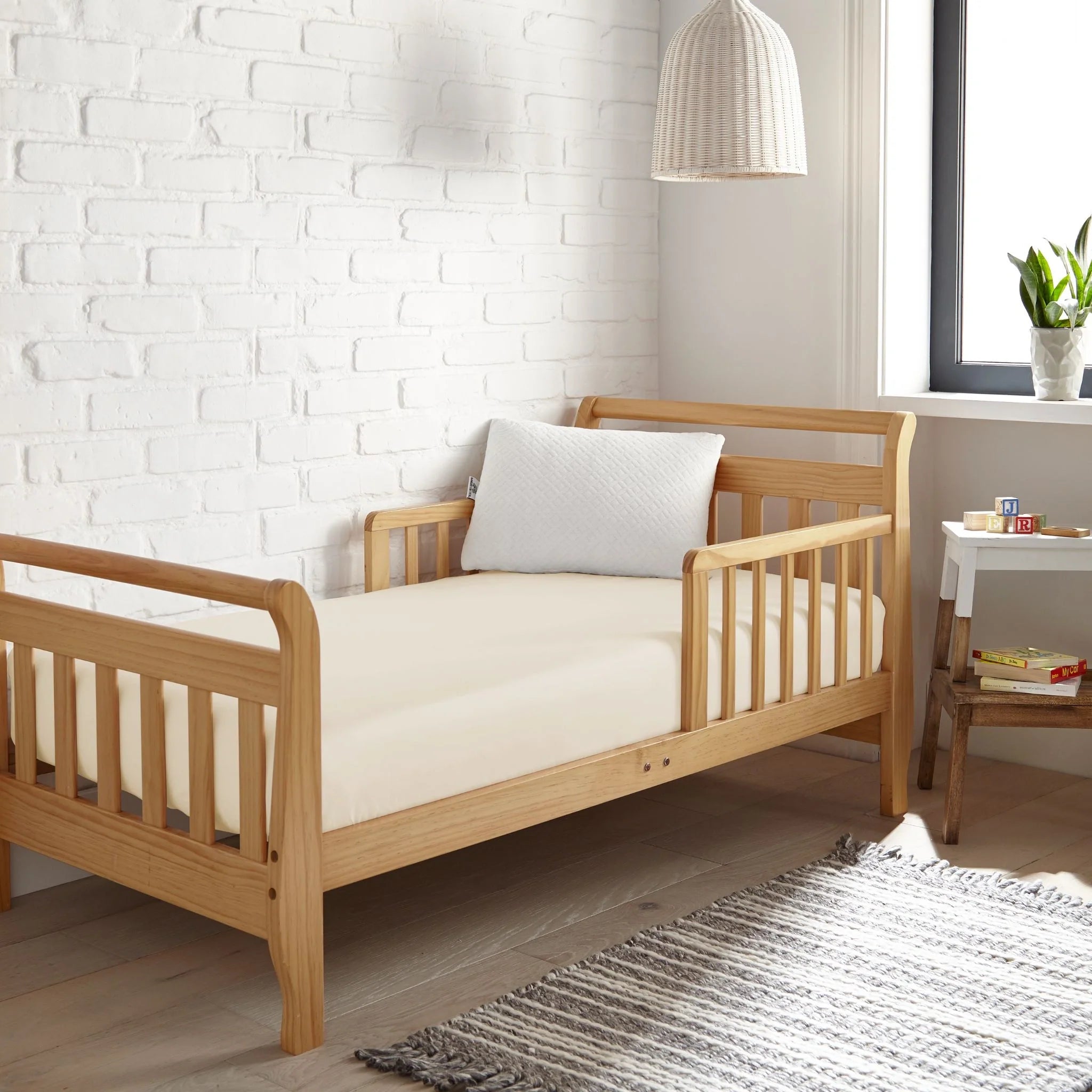 White fitted crib sheet with fine woven look, covering the mattress surface