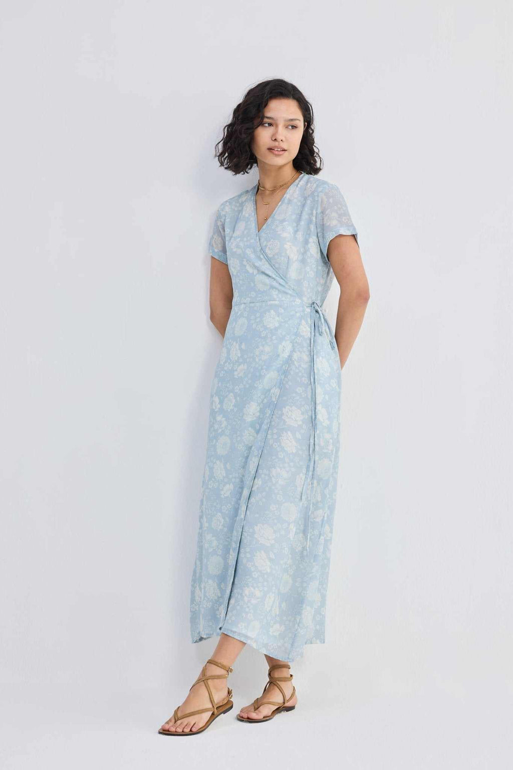 Maxi wrap dress with floral print, V-neckline, and tied waist sash in light blue