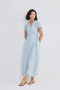 Maxi wrap dress with floral print, V-neckline, and tied waist sash in light blue