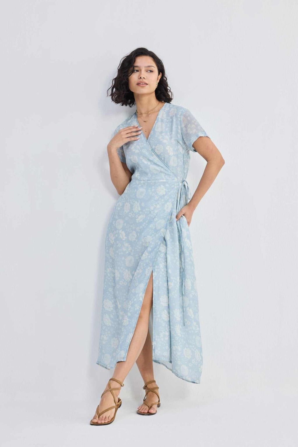Side view of light-blue floral wrap maxi dress with flowing hem and waist sash