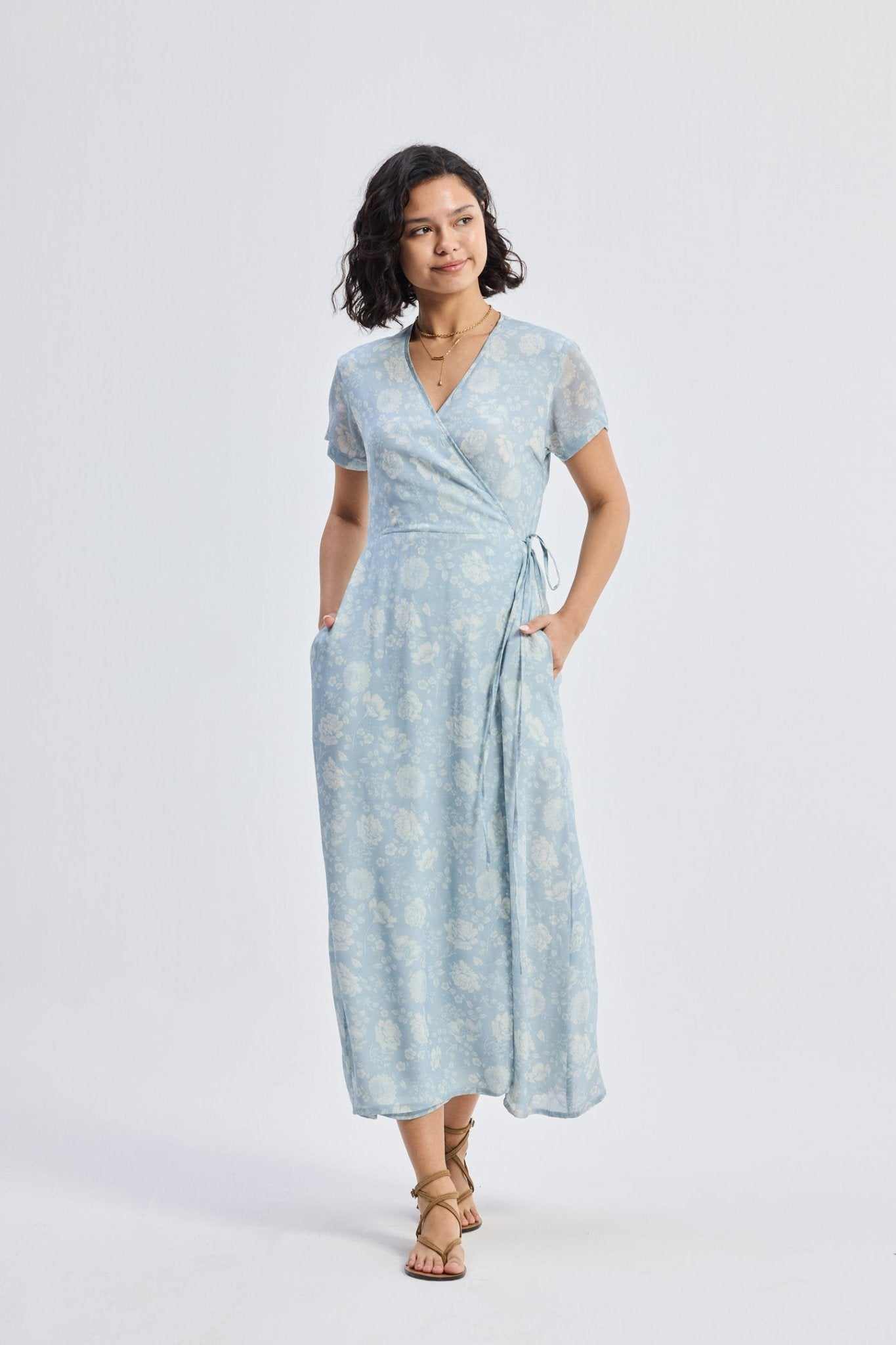 Light-blue floral wrap maxi dress with tied waist sash and flowing, full skirt