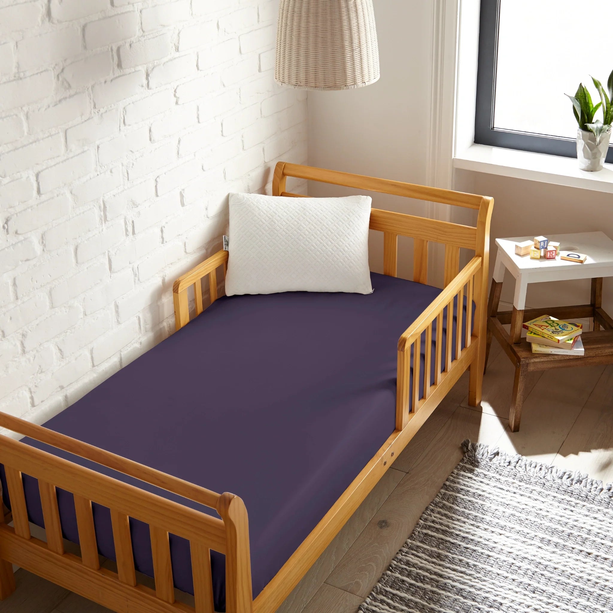 Crib fitted sheet in SLATE blue on toddler bed, smooth flat top and fitted sides.