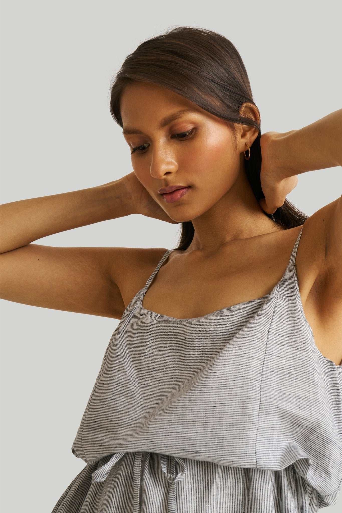 Close-up of pinstriped linen maxi dress: thin straps and gathered ruffle band