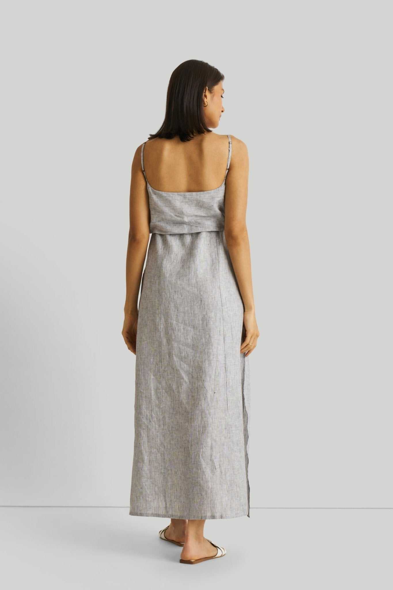 Back view of pinstriped linen maxi dress with spaghetti straps and waist ruffle