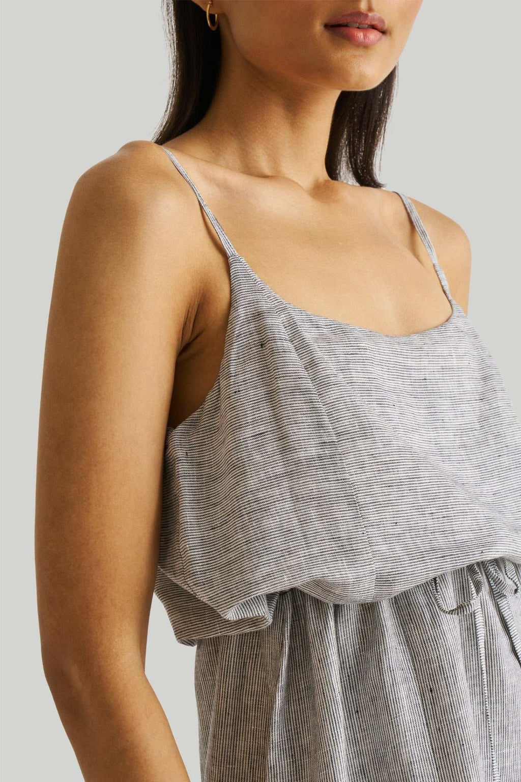 Detail view: spaghetti straps and layered ruffle at the waist of pinstriped maxi dress