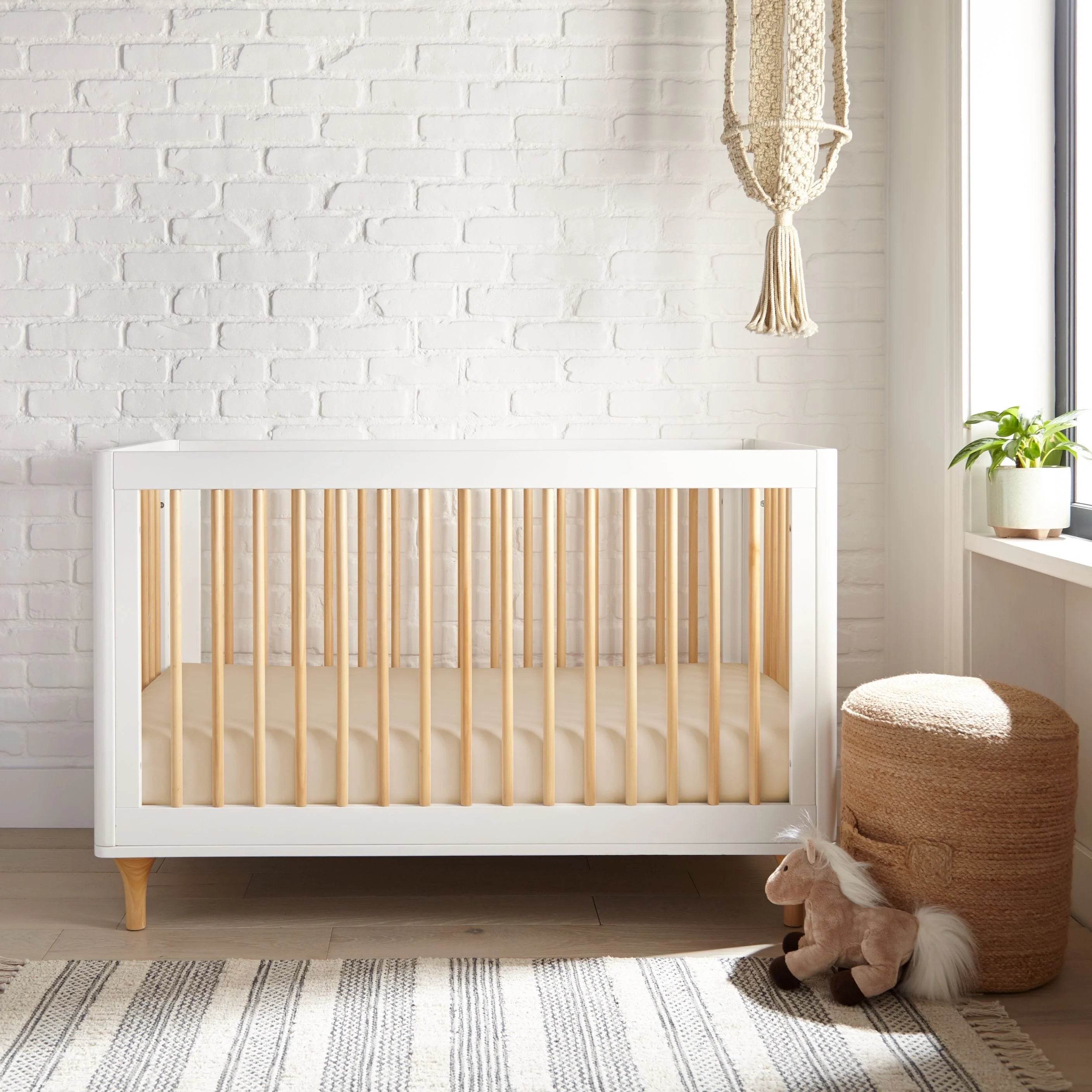 White crib fitted sheet covering the mattress, straight seams and secure corners