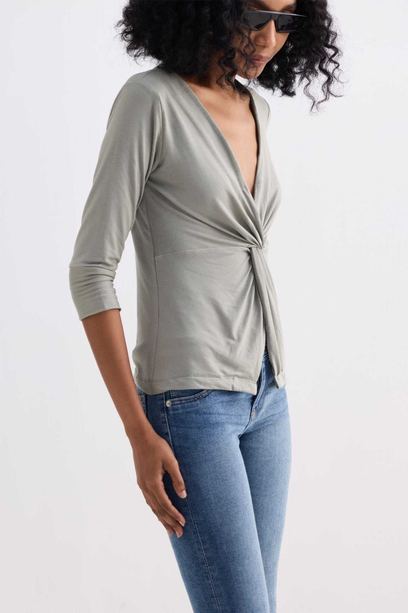 Light olive twist-front knit shirt side view with V-neck and knot detail