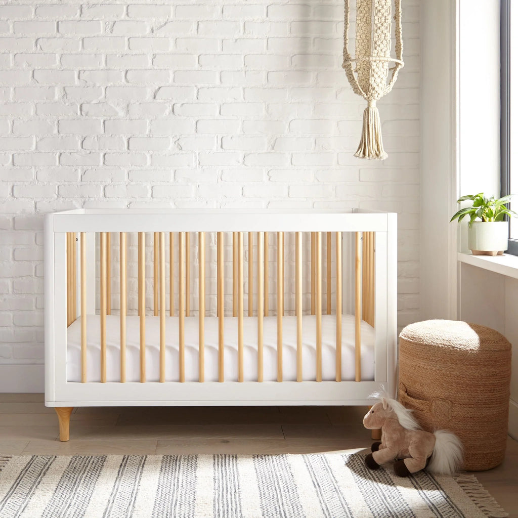 White fitted crib sheet on a crib mattress, with tidy corner fit